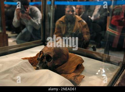 The mummy of King Tut's mother, seen through a glass case, is displayed ...