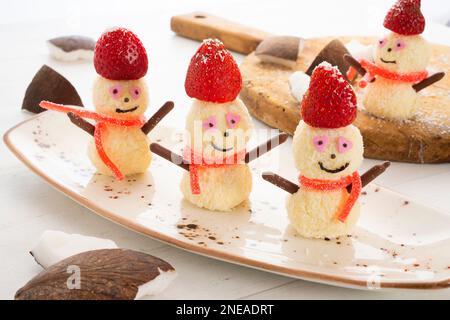 Snowmen made with white chocolate and coconut bonbons. Stock Photo