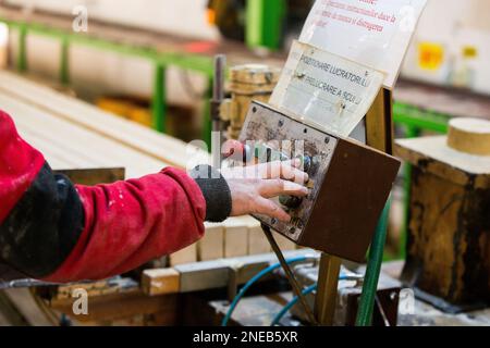A construction worker pressing a button on an electrical machine. Stock Photo