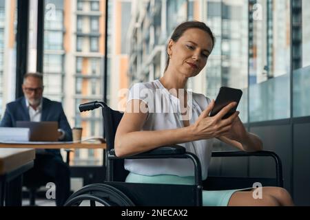 Businesswoman in a wheelchair is chatting on the phone Stock Photo