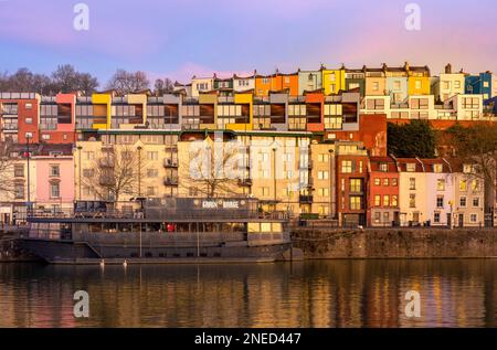 Grain Barge at sunrise seen with colourful traditional and contemporary houses behind. Bristol Marina. UK Stock Photo