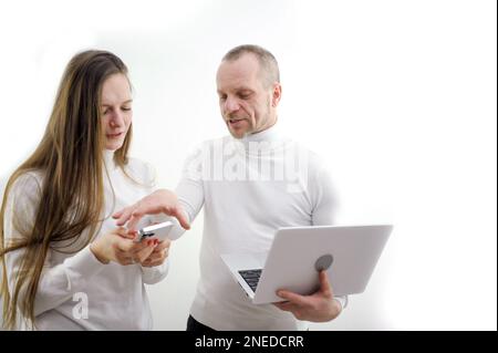 boss nervously takes the phone from employee of subordinate intern in hands of laptop on white background concept lesson training elementary work university study online learning technology newest Stock Photo