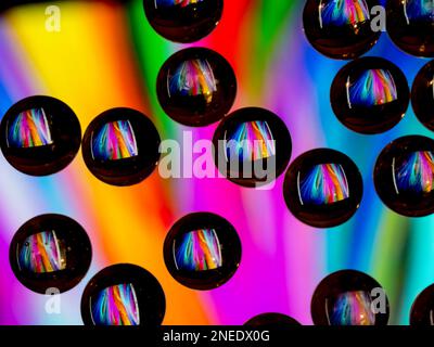 Colorful abstract pattern reflecting in black ringed glass drops Stock Photo