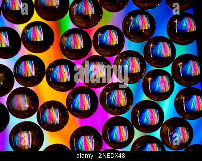 Colorful abstract pattern reflecting in black ringed glass drops Stock Photo