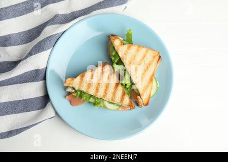 Blue plate with tasty sandwiches on white table, top view Stock Photo