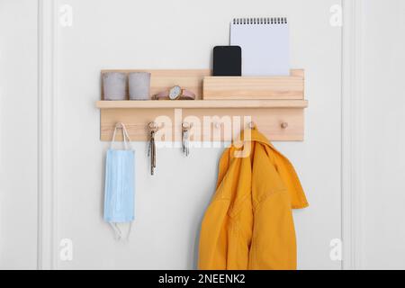 Wooden hanger for keys with different stuff on white wall Stock Photo