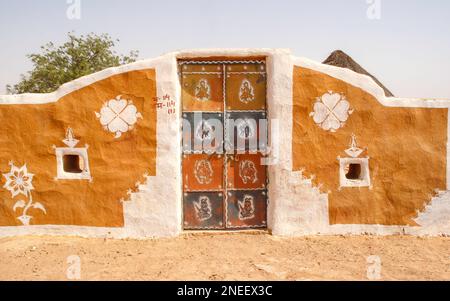 Colourful entrance of tiny Khuri Village, traditional rural Indian mud village, Thar desert, Rajasthan, India Stock Photo
