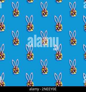 Creative seamless pattern with easter bunny statuette and spring tulips on blue background, easter minimal concept Stock Photo