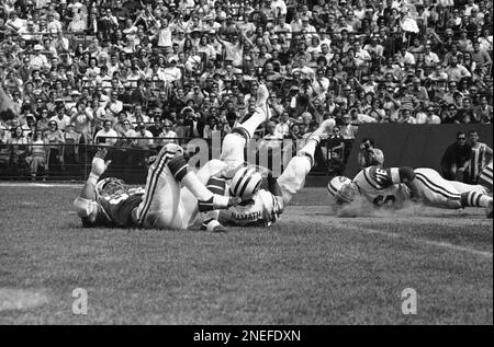 Joe Namath, New York Jets quarterback, leaves the field at Shea Stadium in New  York after the drive against Kansas City Chiefs faltered, Dec. 20, 1969.  Wind, shown kicking up dust around