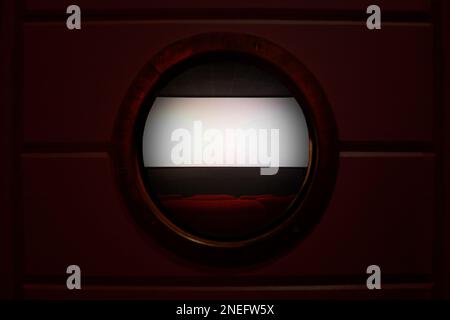 Row of empty red seats in a movie theater with the white projection screen in the background few minutes before the movie begin. The room is seen behi Stock Photo