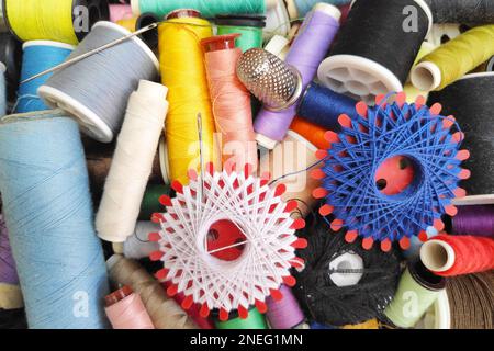Close-up on a sewing kit (thread, sewing needle and thimble). Stock Photo