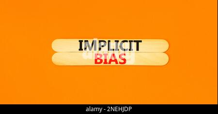 Implicit bias symbol. Concept words Implicit bias on wooden sticks. Beautiful orange table orange background. Business psychology implicit bias concep Stock Photo