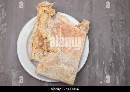 salted dry cod fish on white dish on ceramic Stock Photo