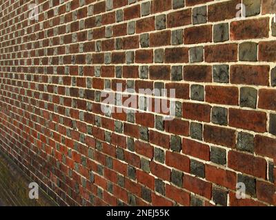 Red and gray bricks alternate in a pattern along a wall in Old City Philadelphia. Stock Photo