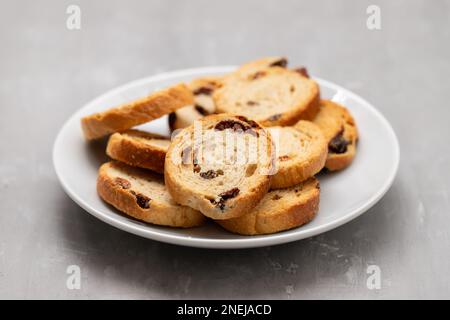 Mini round toasts of bread with raisins on dish on ceramic Stock Photo