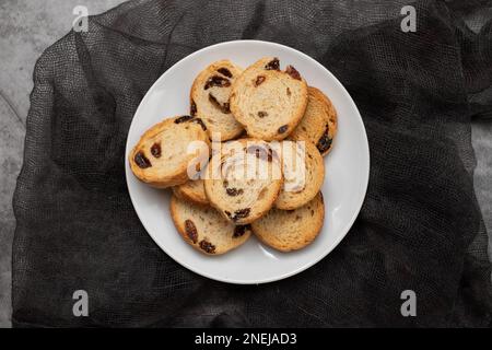 Mini round toasts of bread with raisins on dish on ceramic Stock Photo