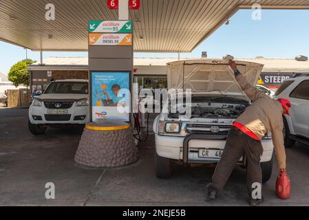 Langebaan, Western Cape, South Africa. 2023. Service station attendant checking water levels on a vehicle during a fuel stop. Stock Photo