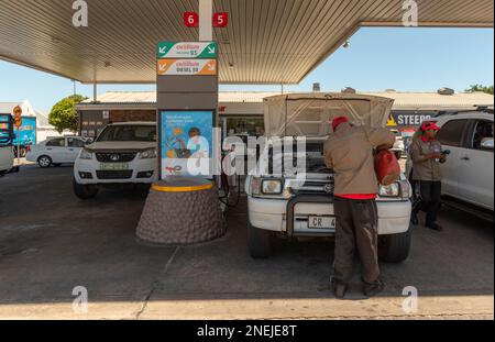 Langebaan, Western Cape, South Africa. 2023. Service station attendant checking water levels on a vehicle during a fuel stop. Stock Photo
