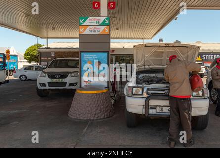 Langebaan, Western Cape, South Africa. 2023. Service station attendant checking water levels on a vehicle during a fuel stop. Stock Photo