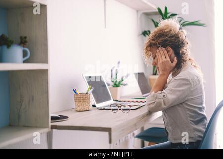 Tired young woman touch stiff neck feeling hurt joint back pain rubbing massaging tensed muscles suffer from fibromyalgia ache after long computer wor Stock Photo