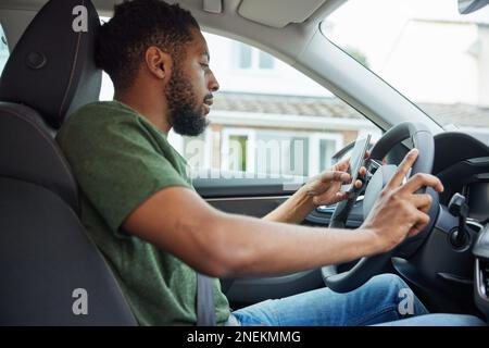 Man Texting Or Using Mobile Phone Whilst Driving Car Stock Photo