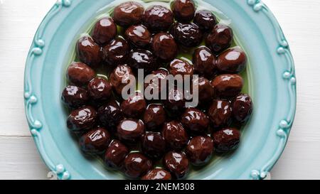 Plate of black olives on white background. Olives and Olive Oil. Stock Photo