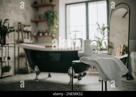 https://l450v.alamy.com/450v/2nemk32/native-hues-organic-shapes-look-of-bathroom-with-big-window-oval-bathtub-in-neutrals-earth-tones-green-palm-plants-candles-bubblebath-leasure-and-rel-2nemk32.jpg