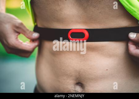 Unrecognizable man putting on the waist band to measure his pulse