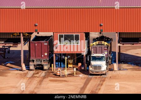 Container trucks have their containers capped or uncapped at his capping station at the UMTRA tailings project in Moab, Utah.  The hoist is removing t Stock Photo