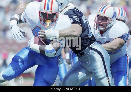 Houston Oilers running back Lorenzo White, left, is talked in the end