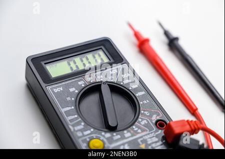 Digital multimeter on a white background. Tool for testing electrical equipment and electrical circuits. Stock Photo
