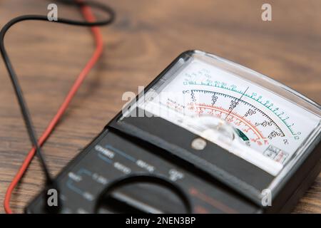 The close-up of the multimeter is on the table. measuring voltage with a tester. Stock Photo
