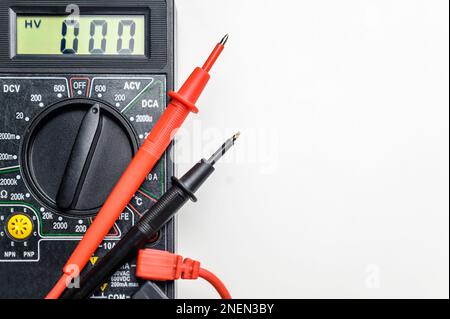 Top view of a tool for testing electrical circuits. Digital multimeter and test leads on a white background. Stock Photo