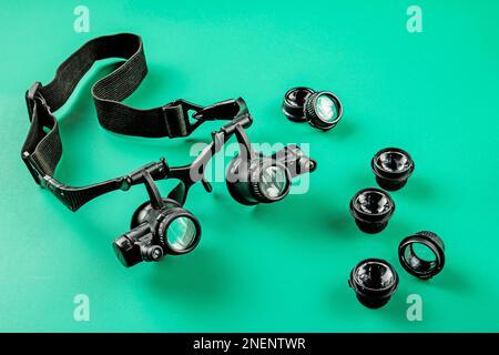 Special glasses for a jeweler with a set of additional lenses with different magnifications on a green background Stock Photo