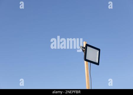 LED street lamp glowing on background of blue sky Stock Photo