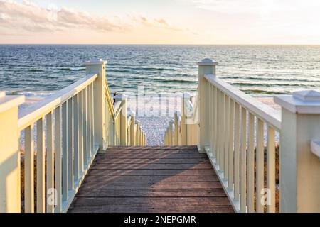 High angle framing view of wooden yellow green white pavilion boardwalk railing stairs steps leading to beach at Gulf of Mexico in Seaside, Florida pa Stock Photo