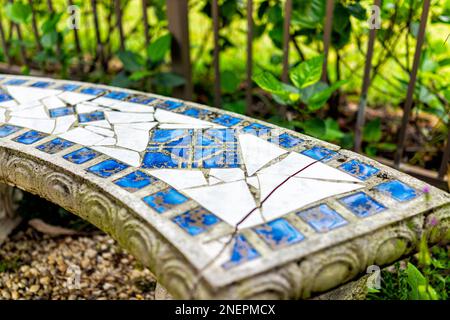 Outdoor green garden with greek white and blue tile bench in backyard of home with nobody in Florida tropical plants Stock Photo