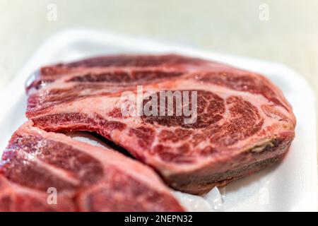 Lamb shoulder blade chops package from butcher on plastic tray with texture closeup of bone and meat and nobody Stock Photo