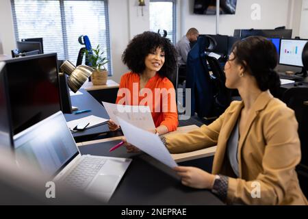 Happy diverse women talking and working in office Stock Photo