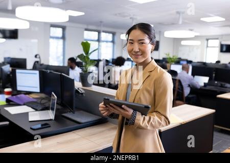 Happy asian businesswoman looking at camera in office Stock Photo