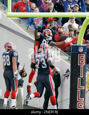 Buffalo Bills' Terrell Owens celebrates his touchdown on the replay screen  as a worker clears snow off the field during the NFL football game against  the Indianapolis Colts in Orchard Park, N.Y.