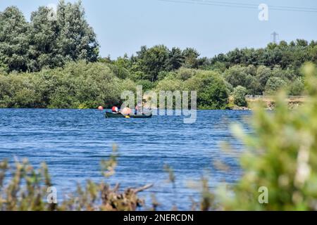 A group of young adults kayaking on a lake in summer. Staffordshire, England, UK Stock Photo