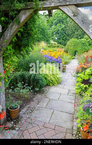 A view through an old wooden pergola at Wollerton Old Hall Gardens garden Wollerton Market Drayton Shropshire England UK Stock Photo