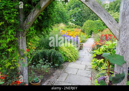 A view through an old wooden pergola at Wollerton Old Hall Gardens garden Wollerton Market Drayton Shropshire England UK Stock Photo