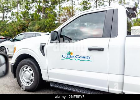 Naples, USA - January 28, 2022: Collier county municipal government pickup sign, truck car driving on highway road in Southwest Florida in downtown tr Stock Photo
