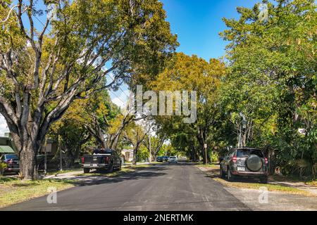 Hollywood, USA - February 12, 2022: Residential narrow street in North Miami, Florida neighborhood community with single family houses homes, cars par Stock Photo