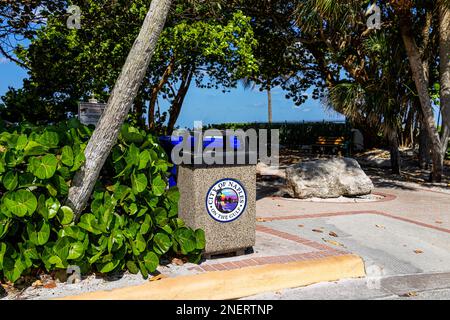 Naples, USA - March 30, 2022: Collier County, Florida gulf of mexico coast with beach access on sunny day and trash can with sign for city of Naples Stock Photo