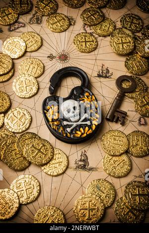 Skull and cross bones lock and skeleton key on old map with rose compass and gold coins. Pirates map. Stock Photo