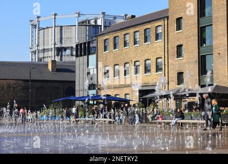 Enjoying warm temperatures during the February 2023 half term holiday on Granary Square at Kings Cross, north London, UK Stock Photo