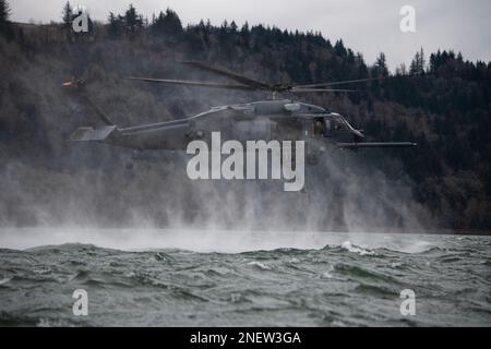 304th Rescue Squadron pararescuemen ascend a rope ladder connected to a 305th RQS HH-60G Pave Hawk helicopter during a combat search and rescue training scenario in the Columbia River Gorge, near Corbett, Oregon, Jan. 12, 2023. The two 943d Rescue Group, Davis-Monthan Air Force Base, Arizona, units carried out various rescue scenarios, ensuring Airmen are able to perform search and rescue operations in a variety of conditions and environments. (U.S. Air National Guard photo by Master Sgt. Steph Sawyer) Stock Photo